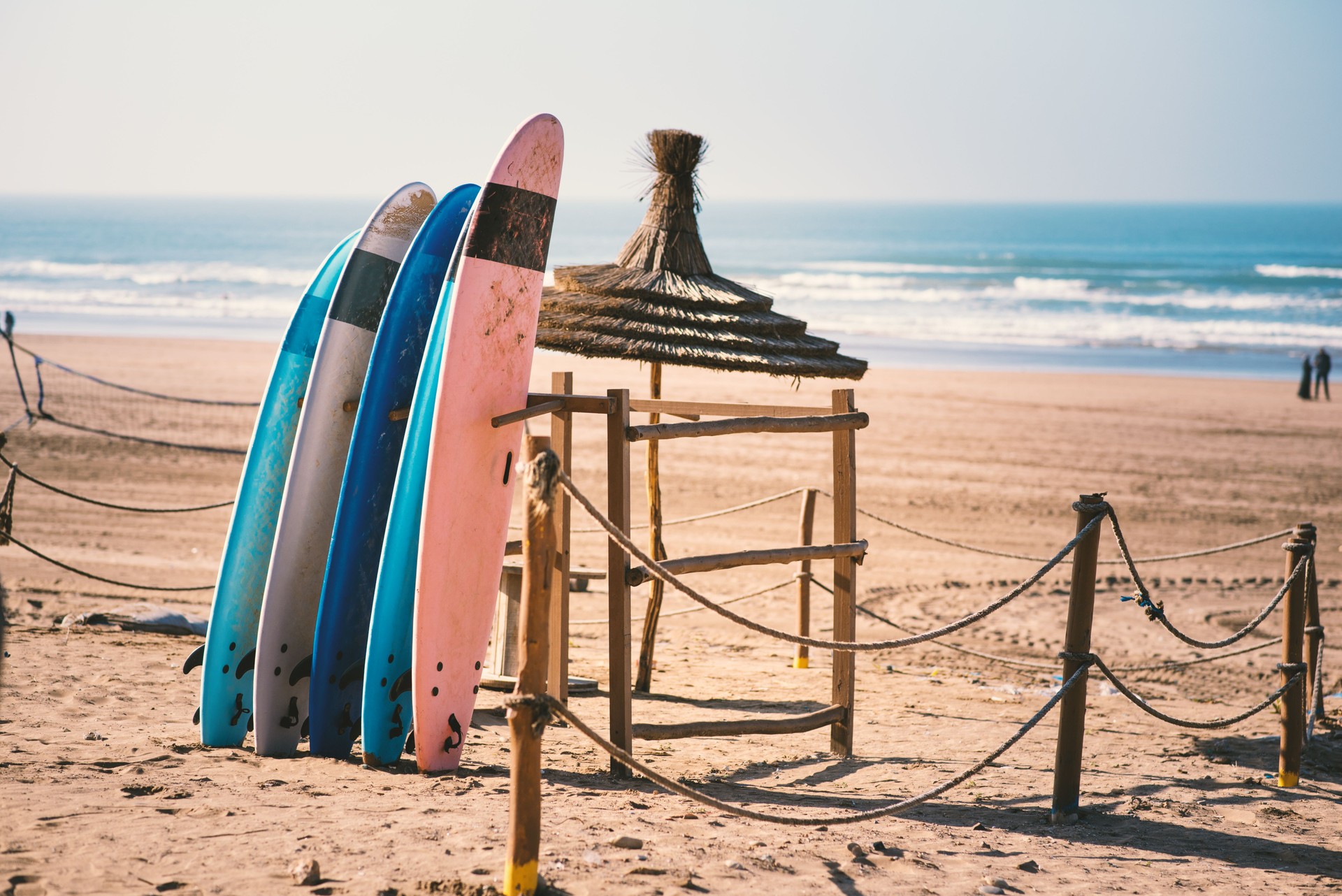 Different colors of surf on a the sandy beach in Casablanca - Morocco. Beautiful view on sandy beach and ocean. Surf boards for renting. Surfer school.